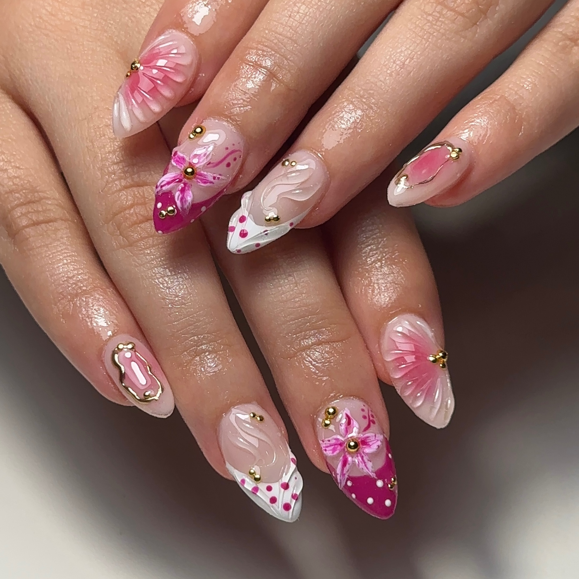 Pink floral nail art with gold beads and polka dot tips